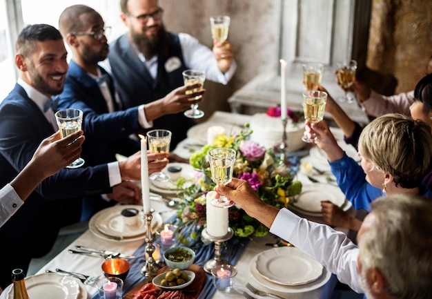 People holding their champagne glasses for a toast at a wedding table