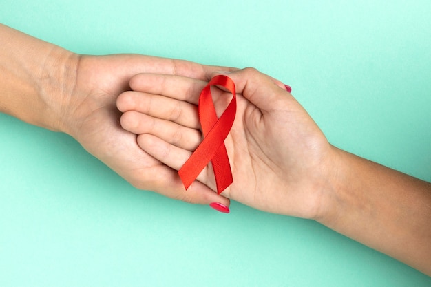 People holding an world aids day red symbol