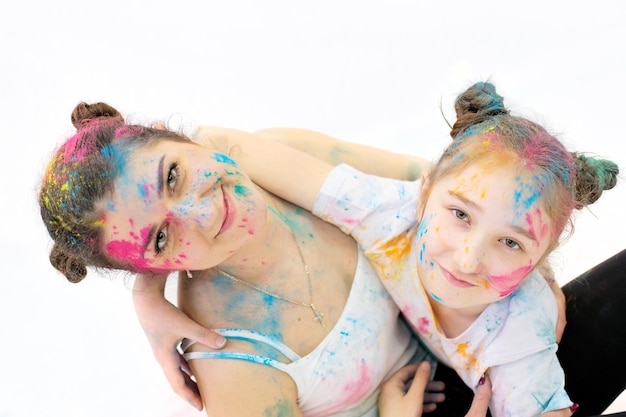 People in holi colors mom and daughter in bright colors on their faces