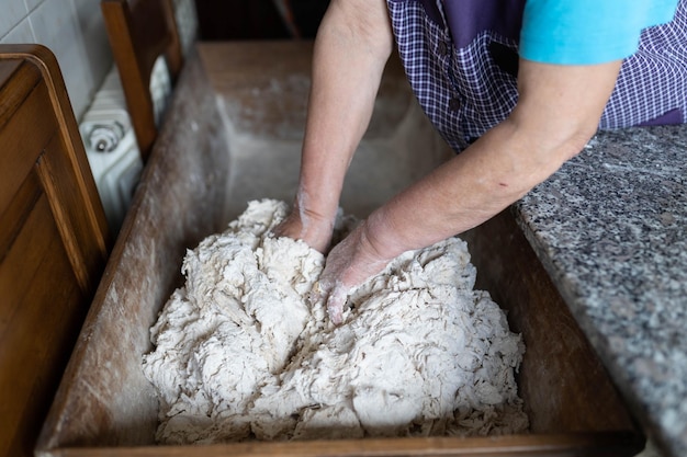 People at home kneading dough to make bread