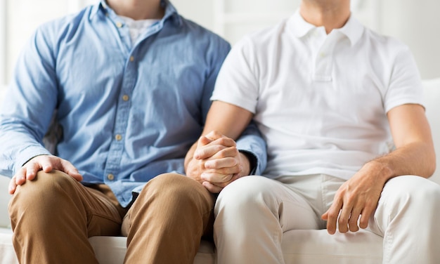 people, homosexuality, same-sex marriage, gay and love concept - close up of happy male gay couple holding hands