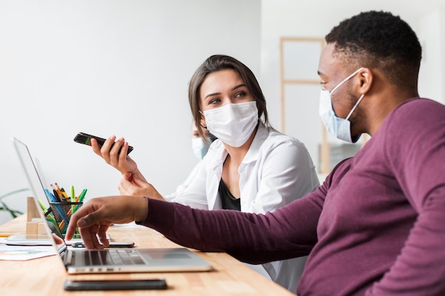 People interacting in the office during pandemic with masks on