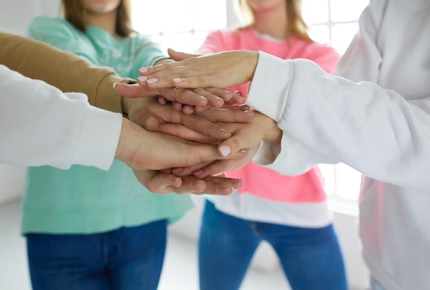 People joining hands young women standing together