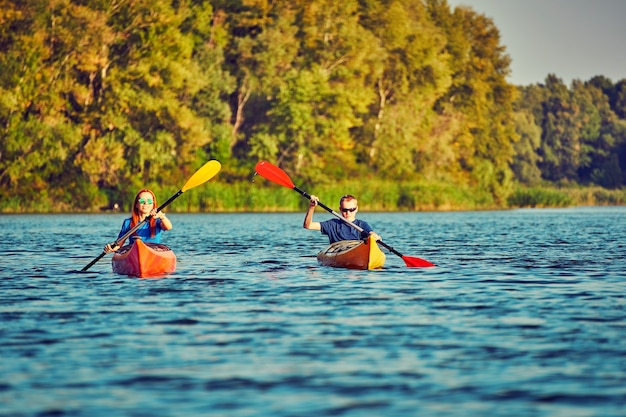 People kayak during sunset in the background. Have fun in your free time.