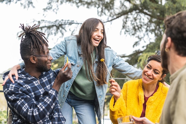 People laughing at happy hour outdoor group of multiracial friends having fun at outside party young adult lifestyle