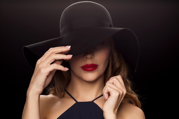 people, luxury and fashion concept - beautiful woman in black hat over dark background