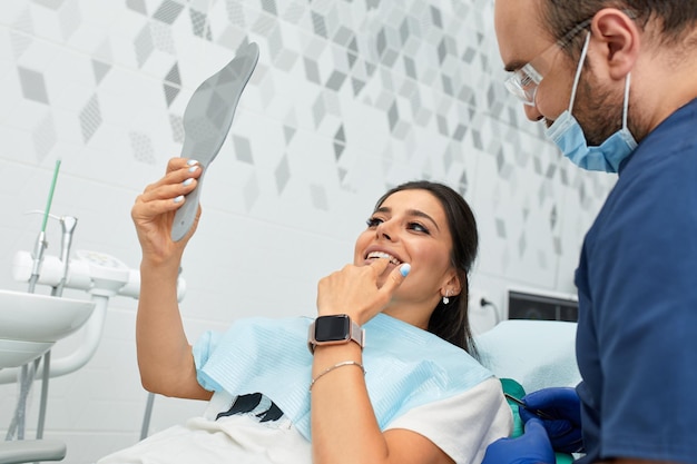 People medicine stomatology and health care concept happy male dentist with woman patient at dental