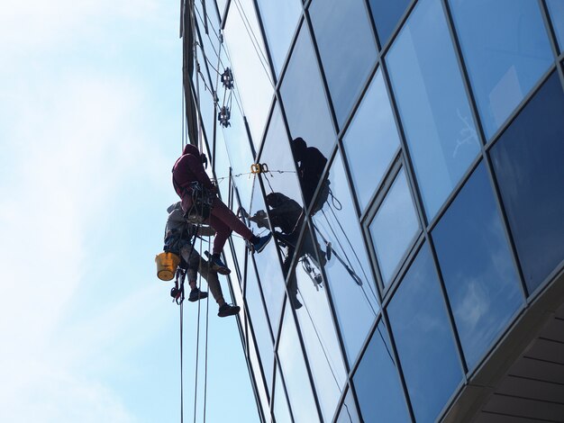 Photo people professionally work at height washing windows