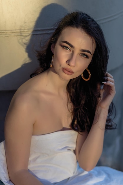 people rest comfort and leisure concept Young woman through the evening streets wrapped in a blanket Portrait of young woman sits on the steps of an old building at dawn