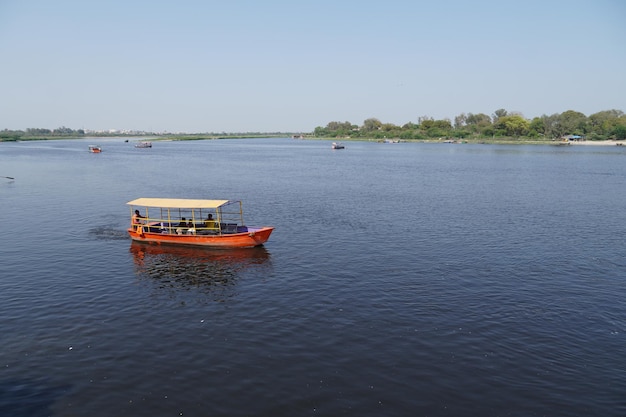 People riding on a boat and enjoying together image yamuna river vrindavan