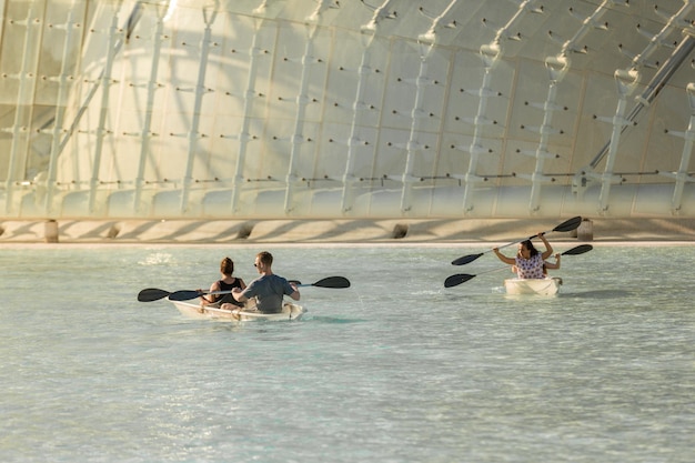 People sailing glass boats in a pool in The city of arts and sciencies in Valencia Spain