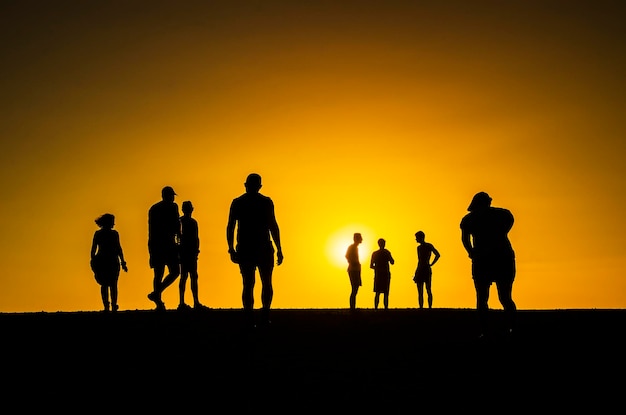 People in silhoutte in an orange background