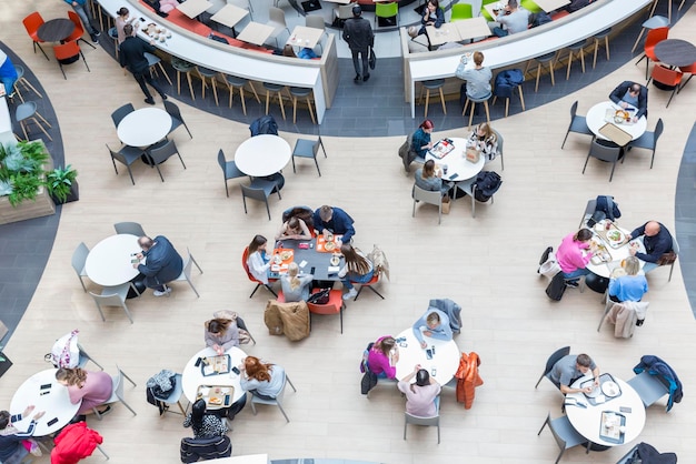 People sit at tables at the food court in the mall Shopping entertainment and snacking Top view Russia Moscow 20221007