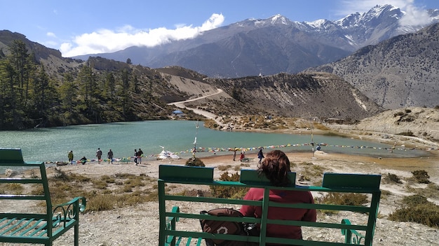 Photo people sitting on bench by mountain against sky