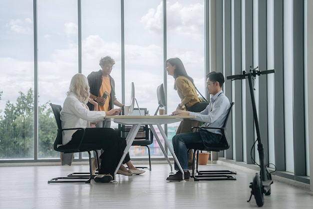 people sitting at a table with a computer and a monitor on the table