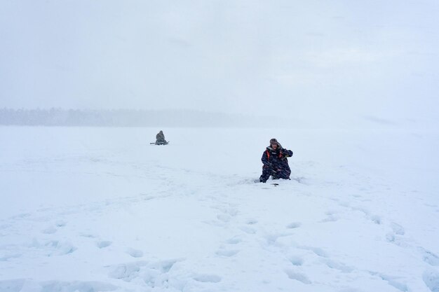 Photo people on snow covered field against sky