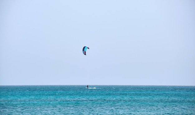 People sportsmen windsurfing and kite surfing in blue ocean water Summer extreme exotic sport concept