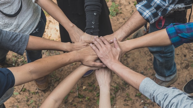 People stacking hands together in teamwork.