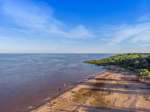 People sunbathe and swim in the lake. Bird's-eye view.