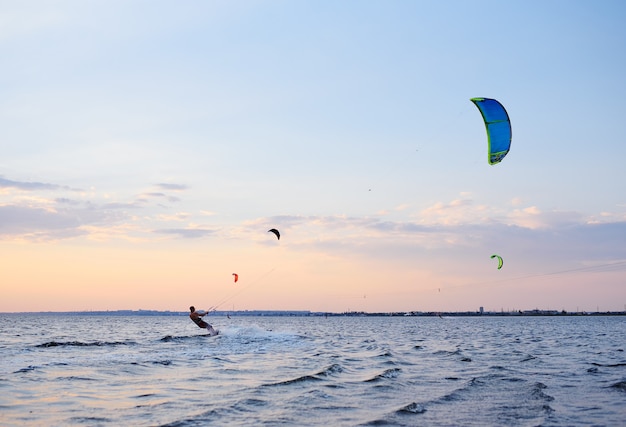 People swim in the sea on a kiteboard or kitesurfing