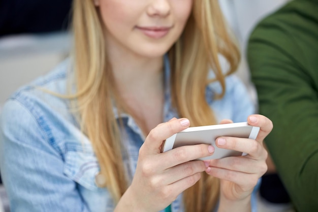 Photo people, technology and internet concept - close up of teenage girl hands with smartphone