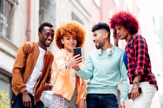 people together look at a mobile cell phone gesturing