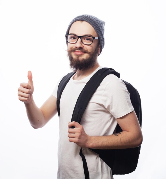 People travel tourism and education concept happy young bearded man in eyeglasses wearing hat with backpack over white background