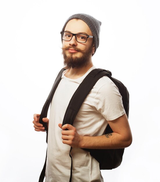 people travel tourism and education concept happy young bearded man in eyeglasses wearing hat with backpack over white background