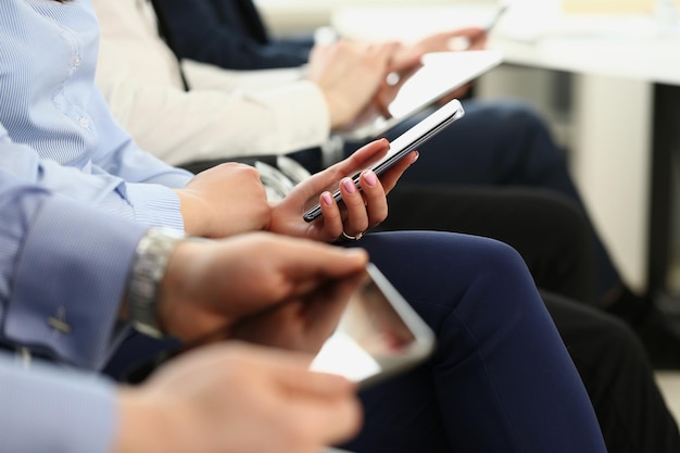 People using mobile phones on meeting modern gadgets in work