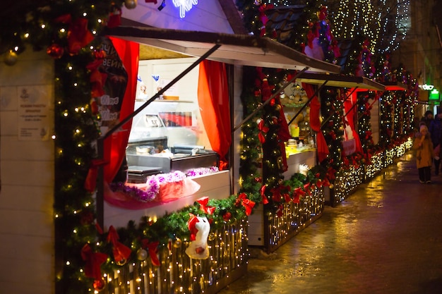 People walk at the Christmas market in the festive decor of the streets. Exhibition and shopping malls in the city center. New Year. Kaluga, Russia, December 2020, editorial.