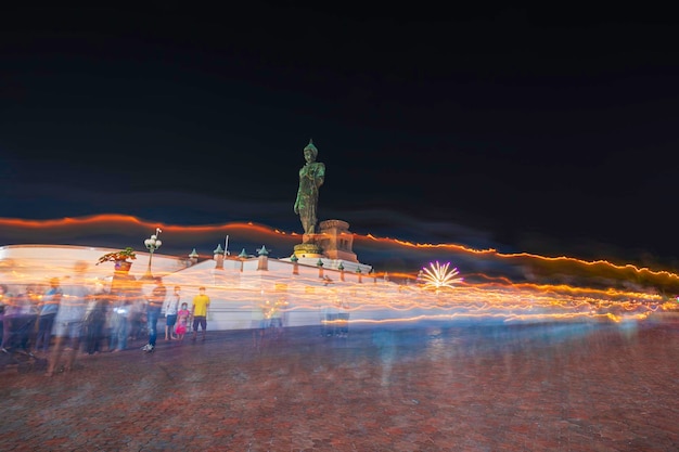 People walk with lighted candles in hand around a temple