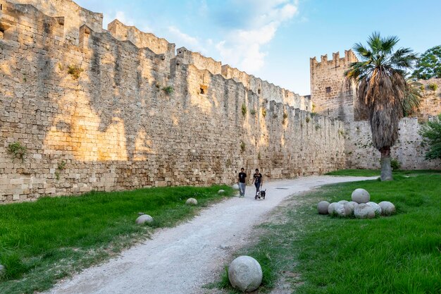 People walking around the walls of Medieval castle in old town of Rhodes island Greece