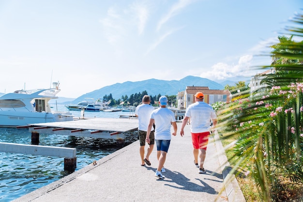 People walking by embankment mountains on background