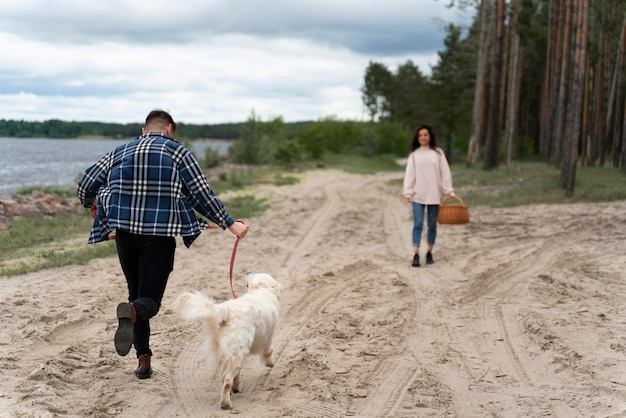 People walking dog on beach full shot