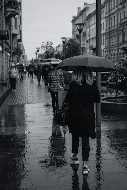 People walking with umbrellas under the autumn rain