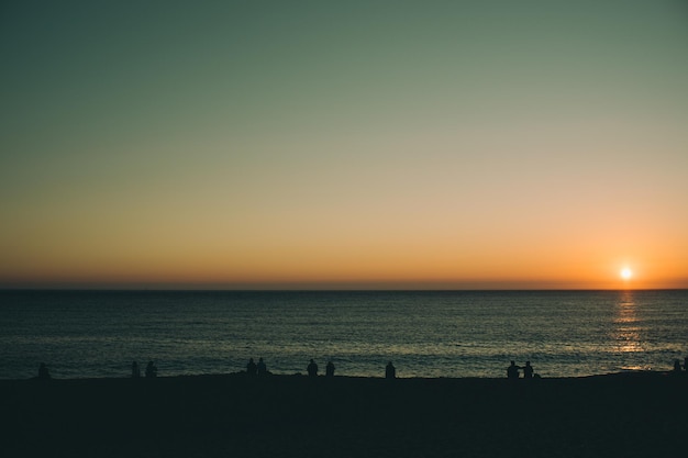 people watching sunset on the beach