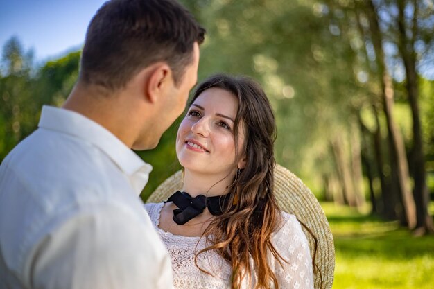 people in wedding dresses stand in the meadow bride looking at groom