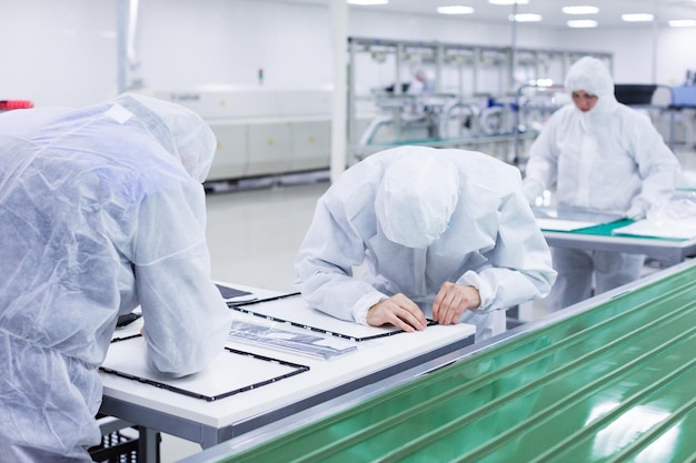 People in white isolating costumes working in laboratory