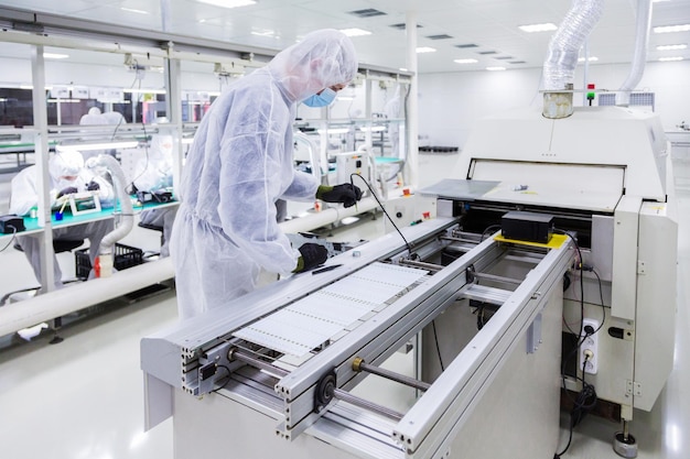 People in white isolating costumes working in laboratory