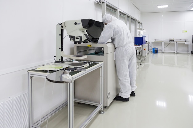 People in white isolating costumes working in laboratory