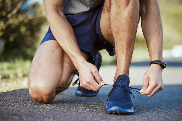 People with goals succeed because they know where theyre going Closeup shot of an unrecognisable man tying his shoelaces while exercising outdoors