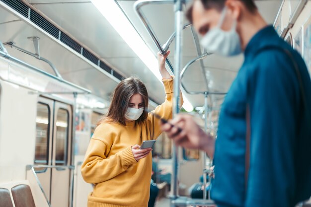 People with smartphones standing in a subway car. coronavirus in the city