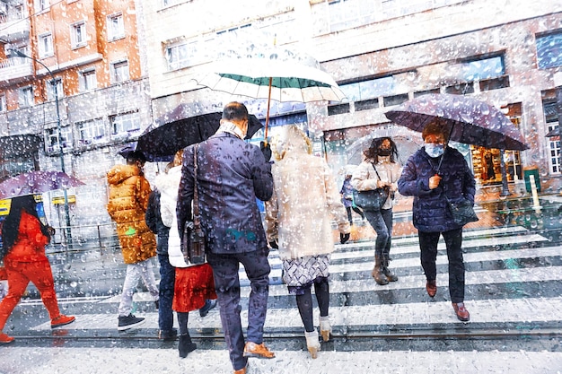 people with an umbrella in rainy days in winter season, bilbao, basque country, spain