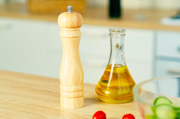 Pepper mill olive oil in jug for adding to food on table in kitchen