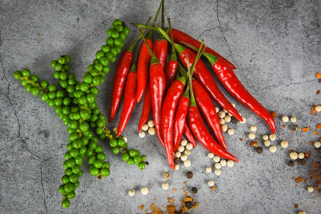 Peppercorns and fresh red chilli on dark , fresh green peppercorn and pepper seed for ingredients cuisine thai food herbs and spices