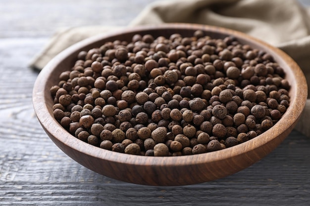 Peppercorns on light grey wooden table closeup