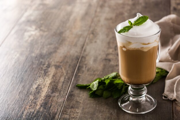 Peppermint coffee mocha for Christmas on wooden table Copy space