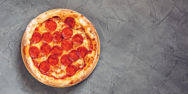 Pepperoni pizza on a gray concrete background