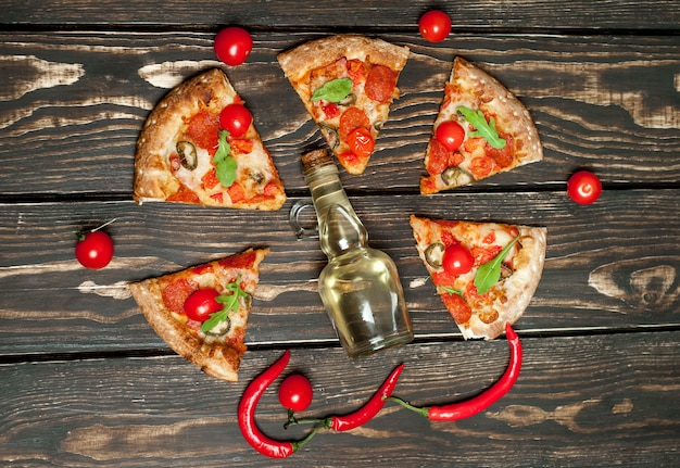 pepperoni pizza slices with ingredients on wood background