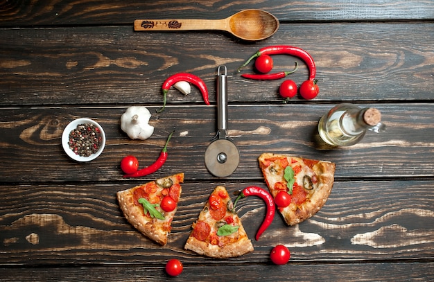 pepperoni pizza slices with ingredients on wood background